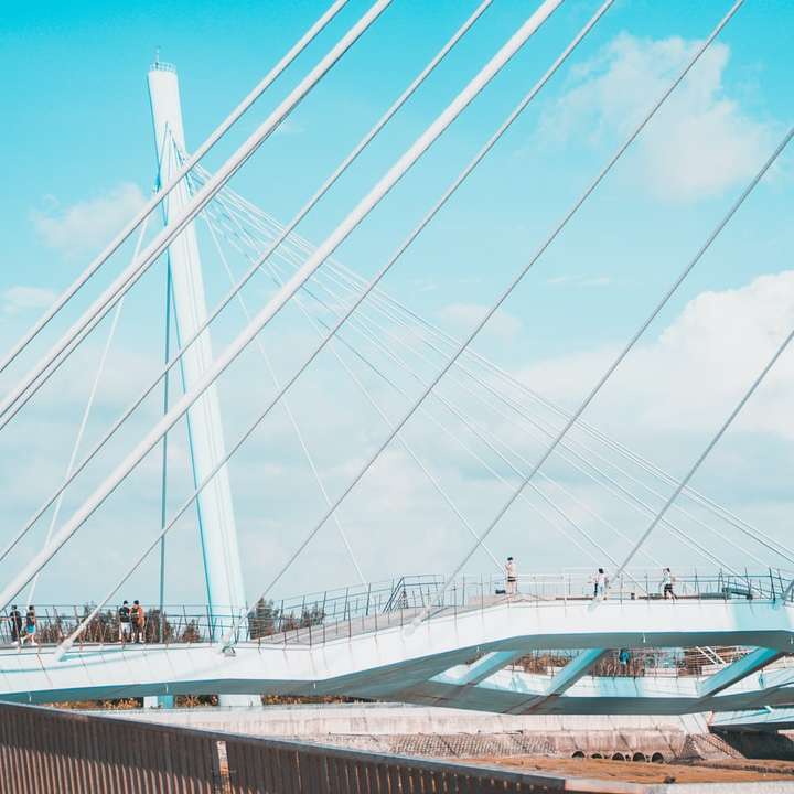άσπρη και μπλε γέφυρα κάτω από άσπρα σύννεφα κατά τη διάρκεια της ημέρας συρόμενο παζλ online