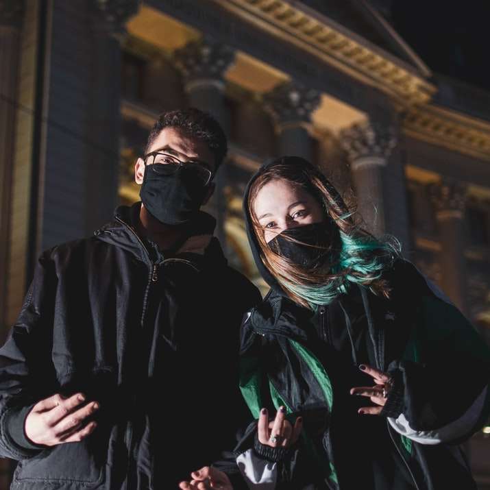 man in zwarte jas staande naast vrouw in groene sjaal online puzzel