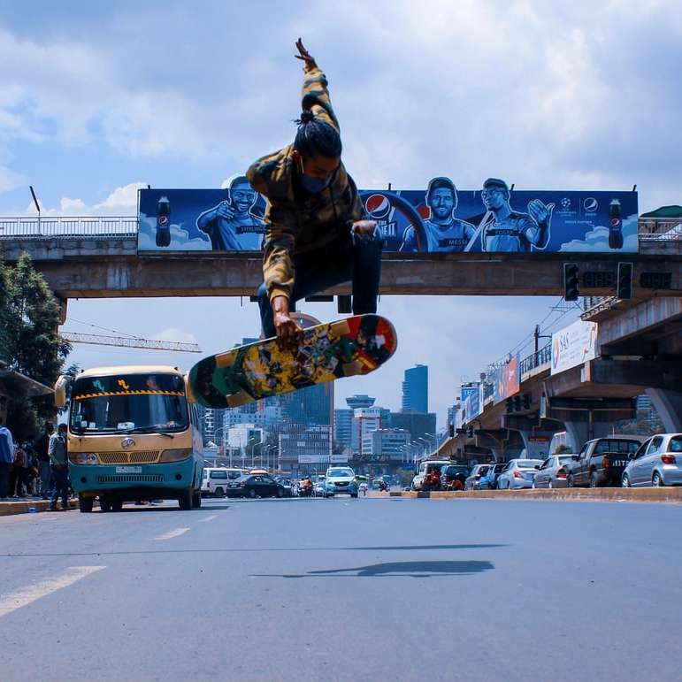 Mann in schwarzer Jacke und Hose reitet Skateboard auf der Straße Schiebepuzzle online
