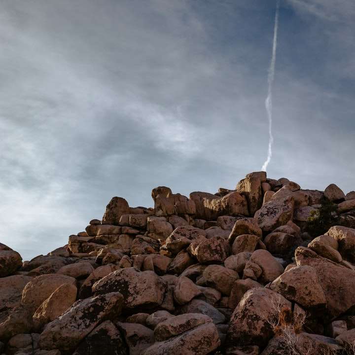 кафяви скали под бели облаци през деня плъзгащ се пъзел онлайн