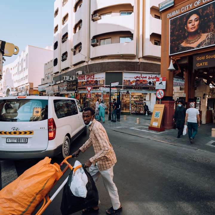 Mann in brauner Jacke, der tagsüber auf Bürgersteig geht Online-Puzzle