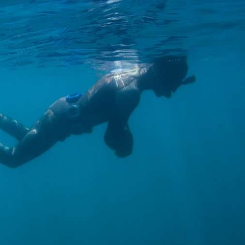 άντρας σε μαύρα σορτς κολύμπι στο νερό online παζλ