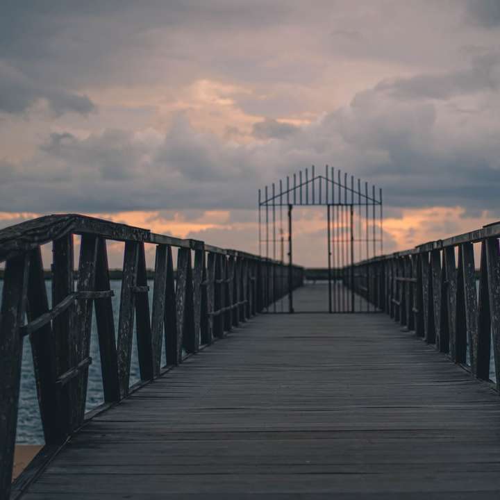 кафяв дървен мост под облачно небе през деня онлайн пъзел