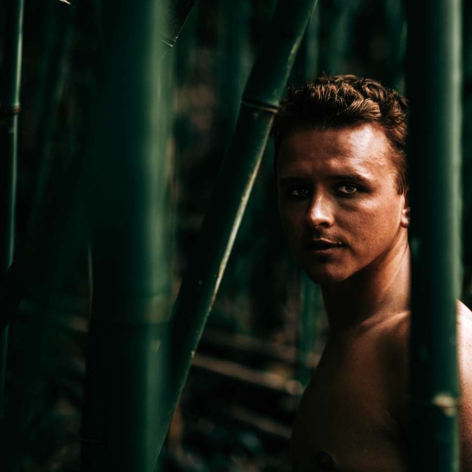 topless Mann, der nahe Bambusbaum steht Schiebepuzzle online