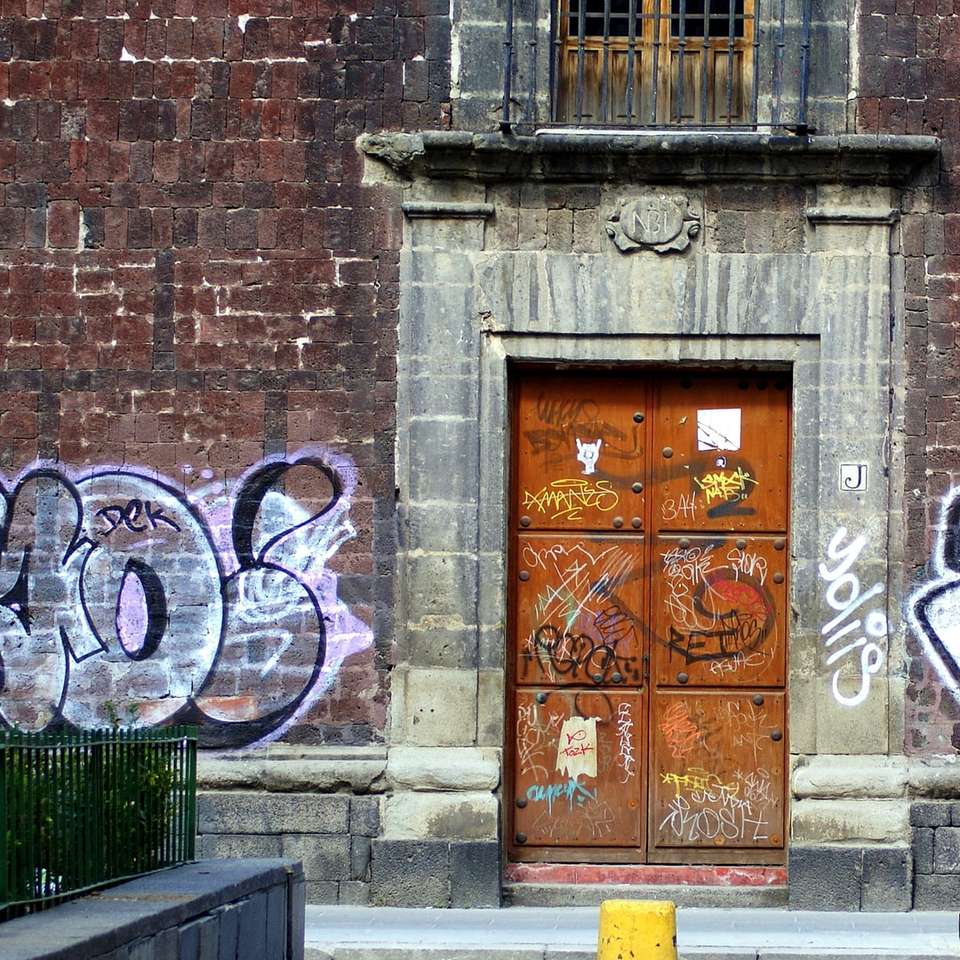 коричневая деревянная дверь с бело-синими граффити онлайн-пазл