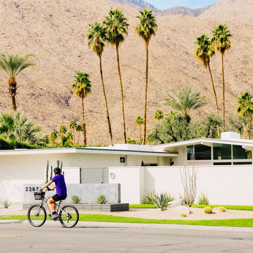 мъж в синя риза, каращ велосипед по пътя през деня онлайн пъзел