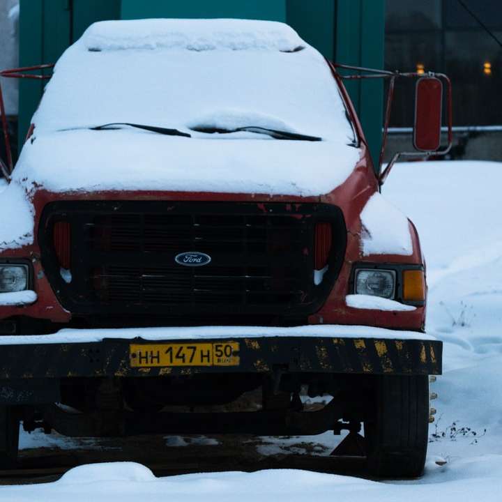 Voiture Ford rouge sur route couverte de neige pendant la journée puzzle coulissant en ligne