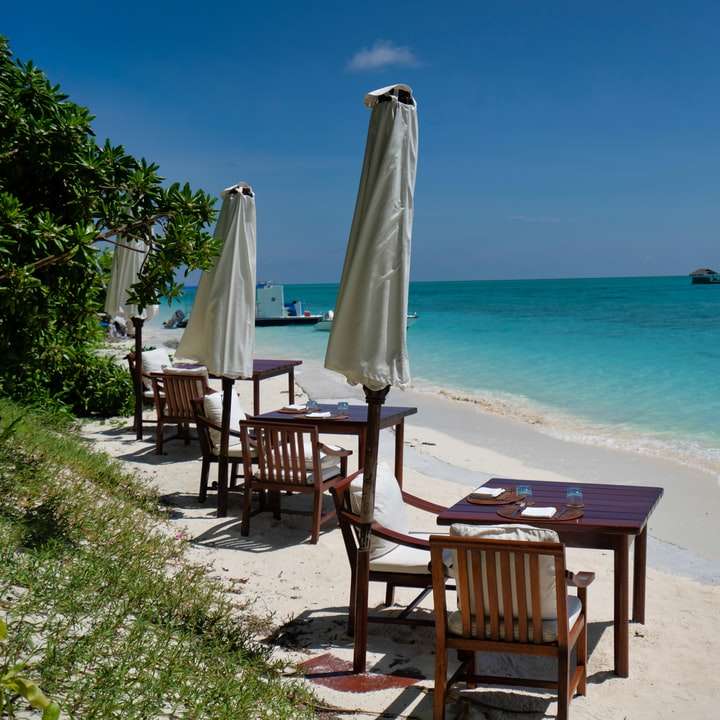 коричневые деревянные стулья на пляже в дневное время онлайн-пазл