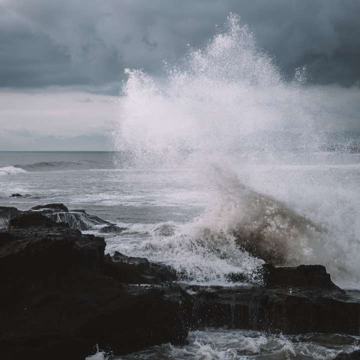 havsvågor som kraschar på stenar under dagtid Pussel online