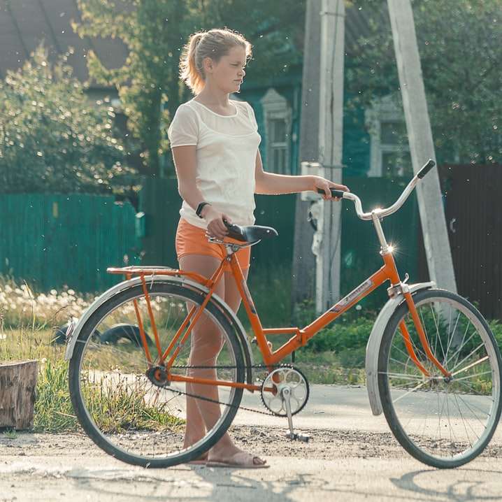 niño con camisa de vestir blanca montando bicicleta roja puzzle deslizante online