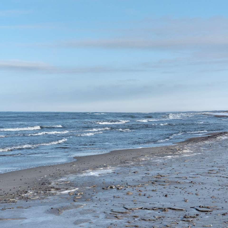 havsvågor som kraschar på stranden under dagtid glidande pussel online