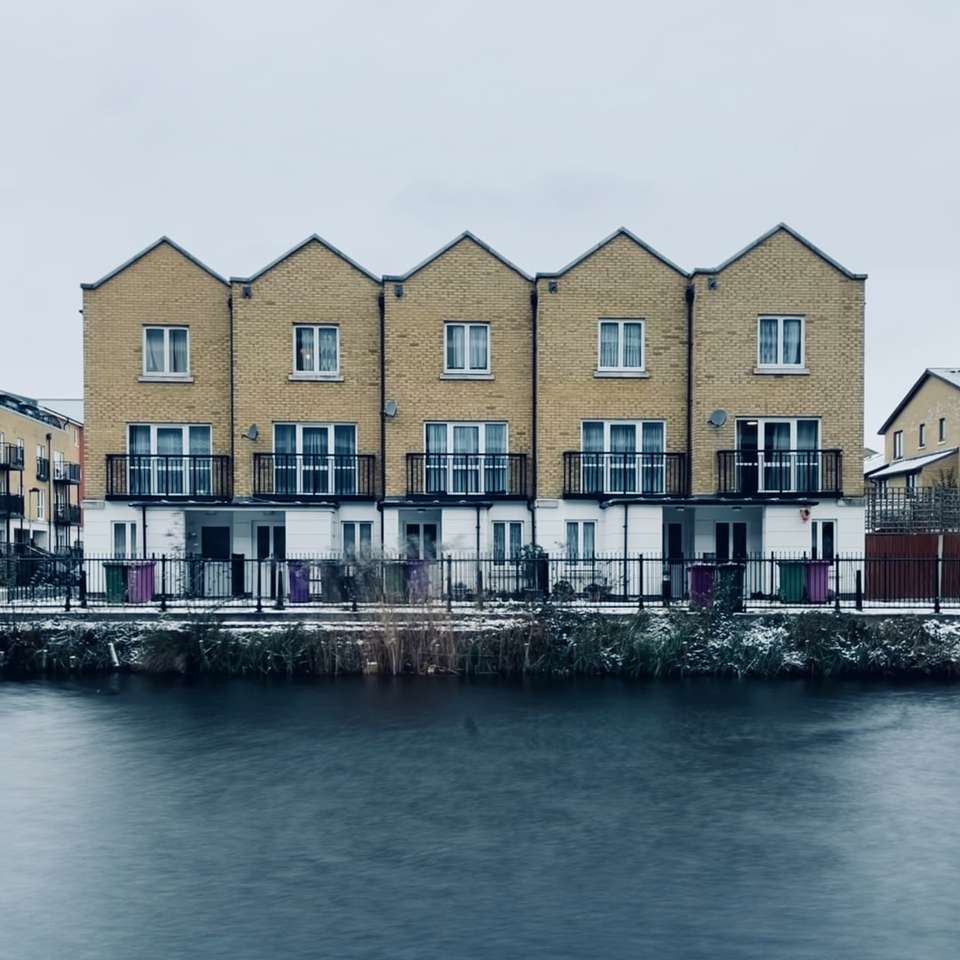 brązowy i biały betonowy budynek w pobliżu zbiornika wodnego puzzle online