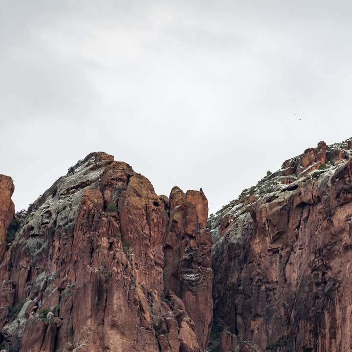 montagna rocciosa marrone sotto il cielo bianco durante il giorno puzzle online
