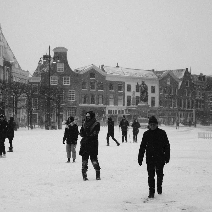 άνθρωποι που περπατούν σε χιονισμένο έδαφος κοντά σε κτίριο συρόμενο παζλ online