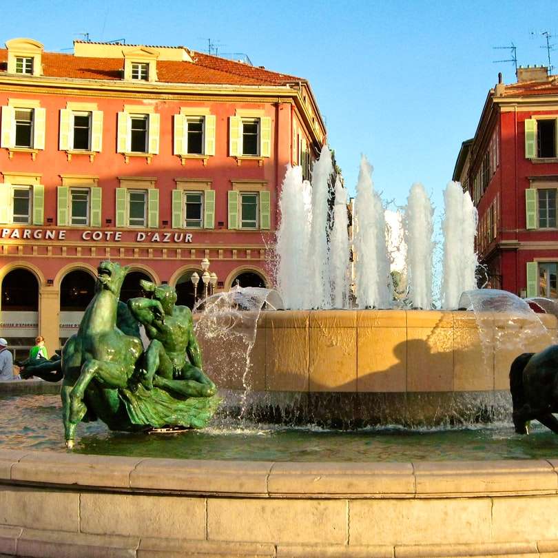 czarna fontanna posągu przed brązowym betonowym budynkiem puzzle przesuwne online
