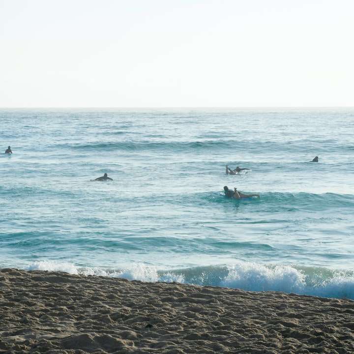 άτομα που κάνουν σερφ στα κύματα της θάλασσας κατά τη διάρκεια της ημέρας συρόμενο παζλ online