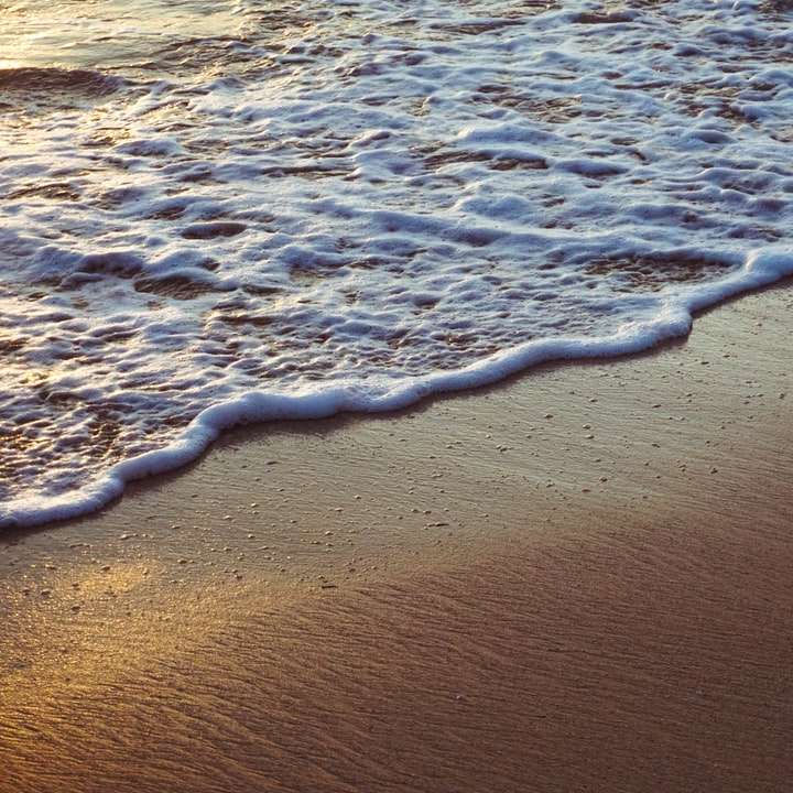 Olas del mar rompiendo en la orilla durante el día puzzle deslizante online