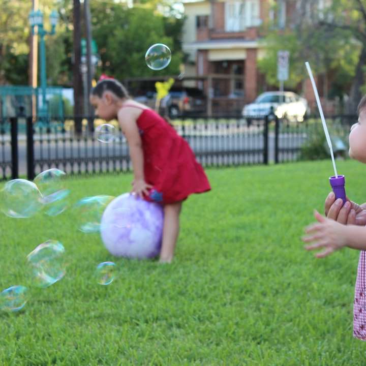 flicka i rosa och vit rutig skjorta som leker med bubblor glidande pussel online