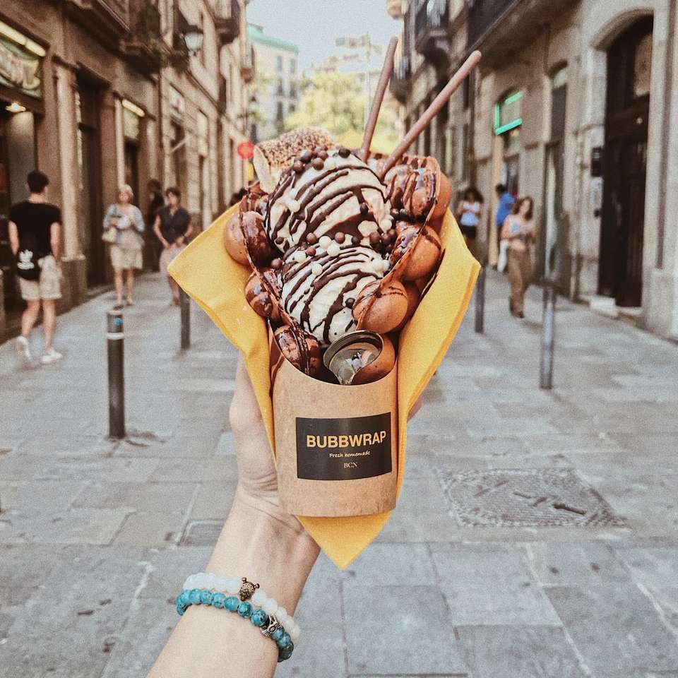 persona sosteniendo helado de plástico de burbujas rompecabezas en línea