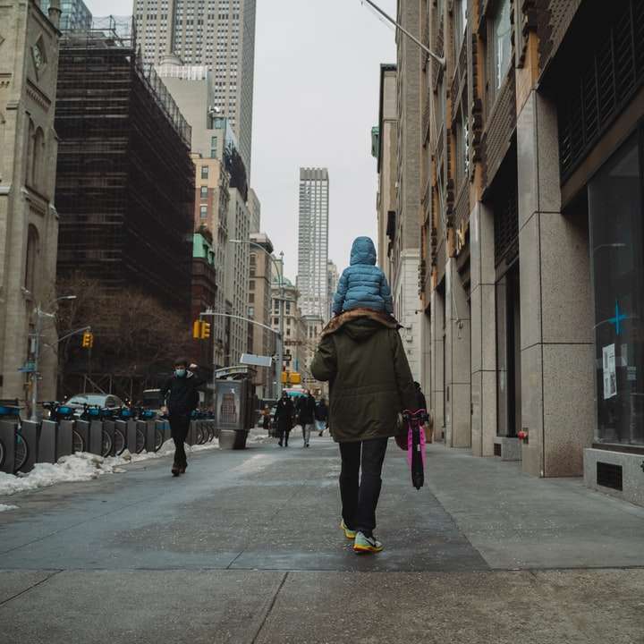 човек в черно яке, ходещ през тротоара през деня онлайн пъзел