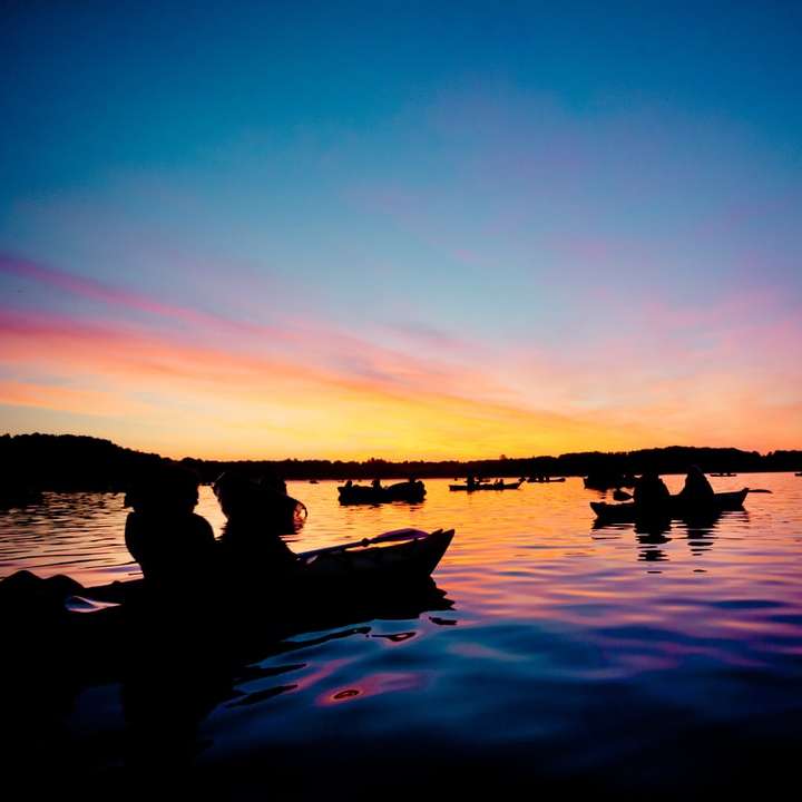 силует людей на човні під час заходу сонця розсувний пазл онлайн
