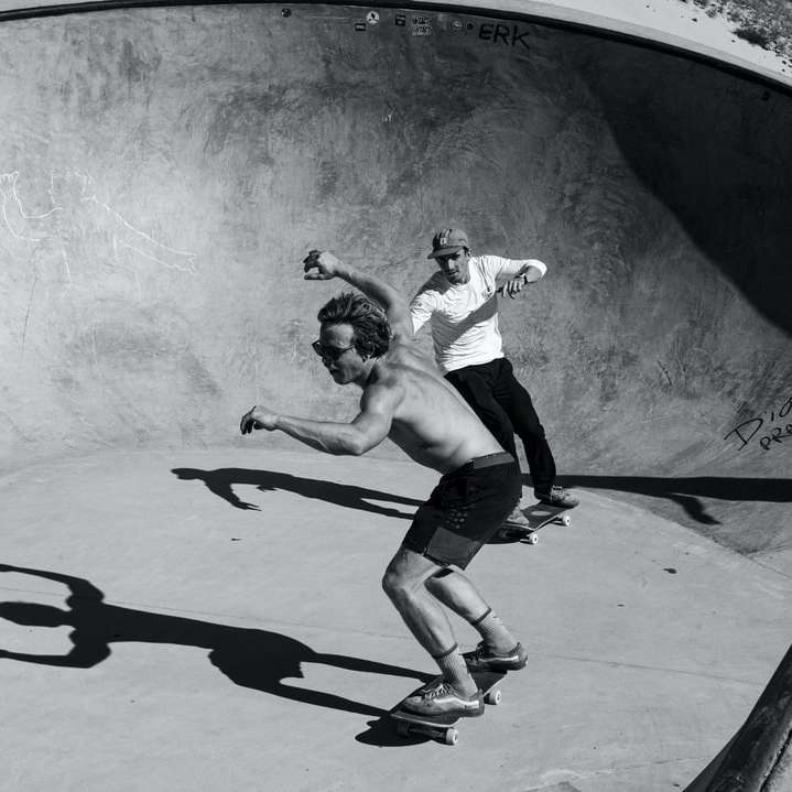 man in wit overhemd en zwarte korte broek springen op skateboard online puzzel