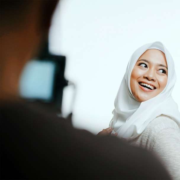 Mujer en hijab blanco y camisa de manga larga negra rompecabezas en línea