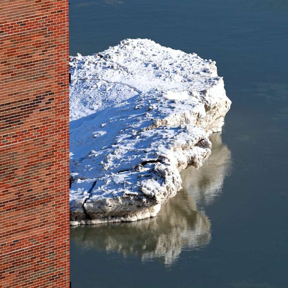 brown brick wall near body of water sliding puzzle online