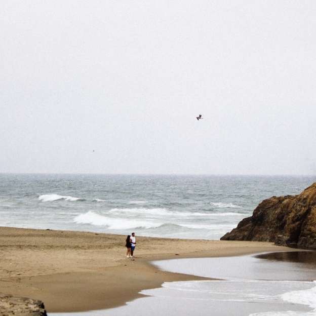 άτομα που περπατούν στην παραλία κατά τη διάρκεια της ημέρας συρόμενο παζλ online