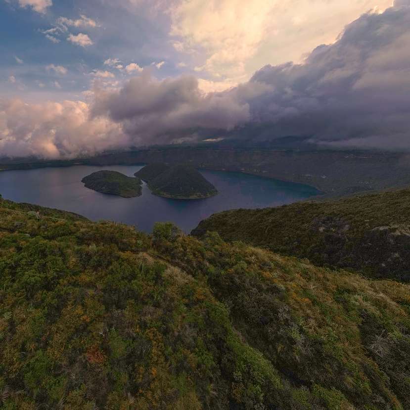 Flygfoto över sjön mellan gröna berg Pussel online