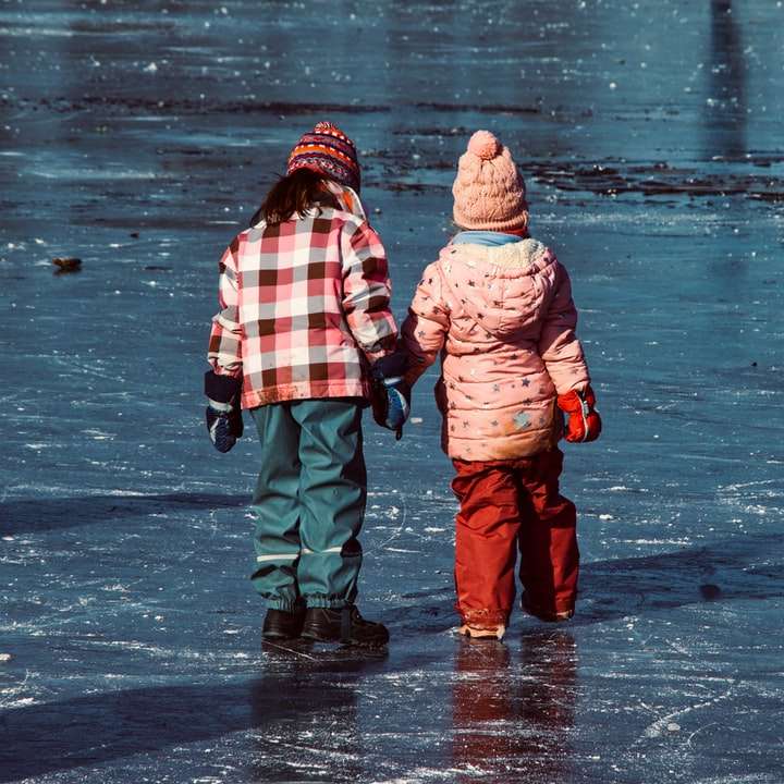 2 деца в червено и бяло яке, ходещи по мокър път плъзгащ се пъзел онлайн