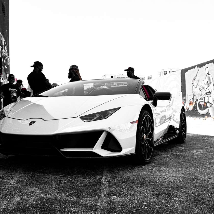 Lamborghini Aventador blanco estacionado junto al hombre rompecabezas en línea