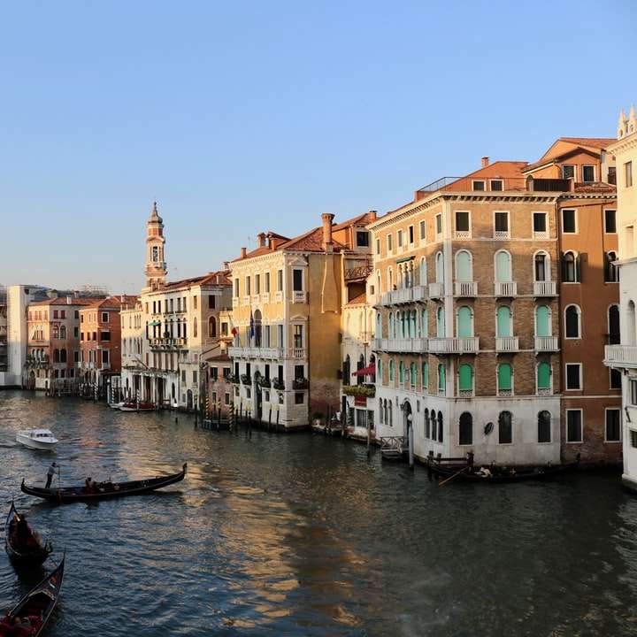 Barco en el río entre edificios durante el día. puzzle deslizante online