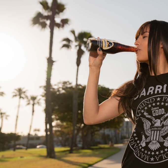 γυναίκα σε μαύρο και άσπρο μπλουζάκι πίνοντας κόκα κόλα συρόμενο παζλ online