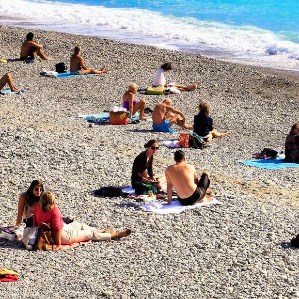 昼間にビーチの海岸に座っている人 オンラインパズル