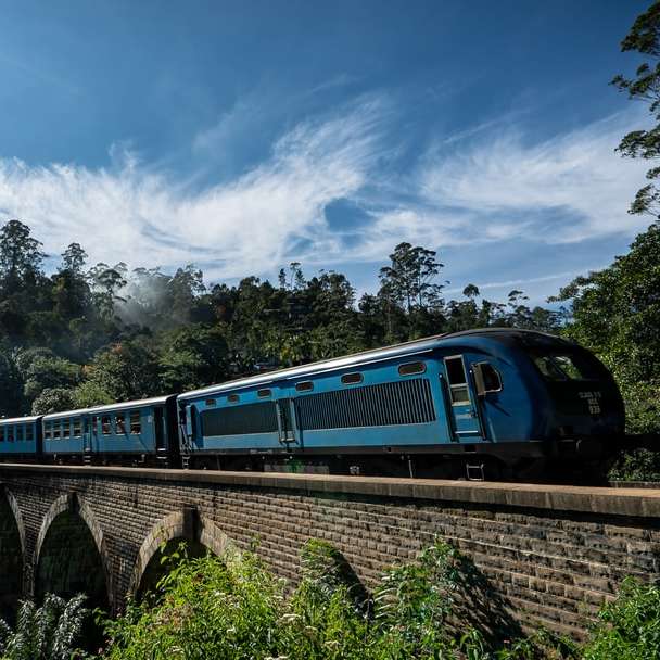 modrý vlak na železnici pod modrou oblohou během dne posuvné puzzle online