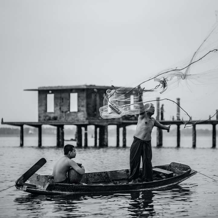 grayscale photo of man in boat sliding puzzle online