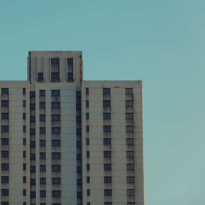 clădire din beton alb și maro sub cer albastru puzzle online