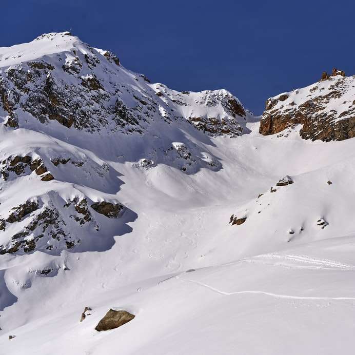 oameni mergând pe munte acoperit de zăpadă în timpul zilei puzzle online