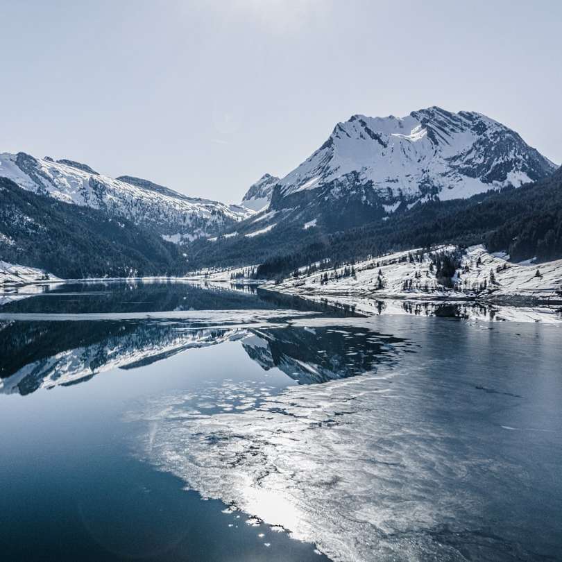 besneeuwde bergen in de buurt van meer overdag schuifpuzzel online