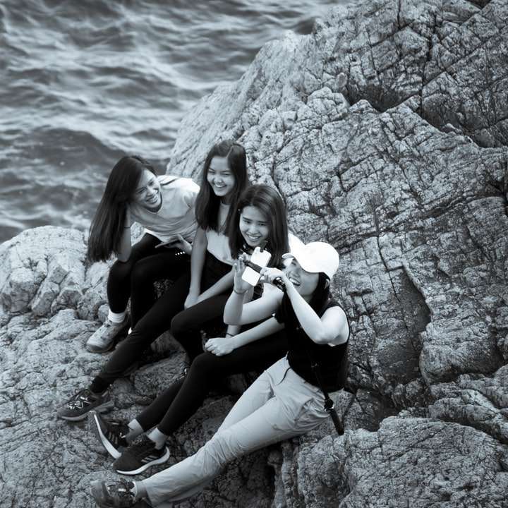 2 Frauen sitzen tagsüber auf Felsen in der Nähe von Gewässern Online-Puzzle