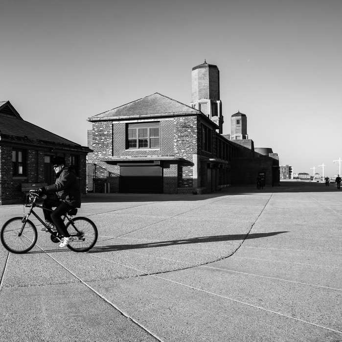 fotografie în tonuri de gri a omului călare pe bicicletă pe drum puzzle online