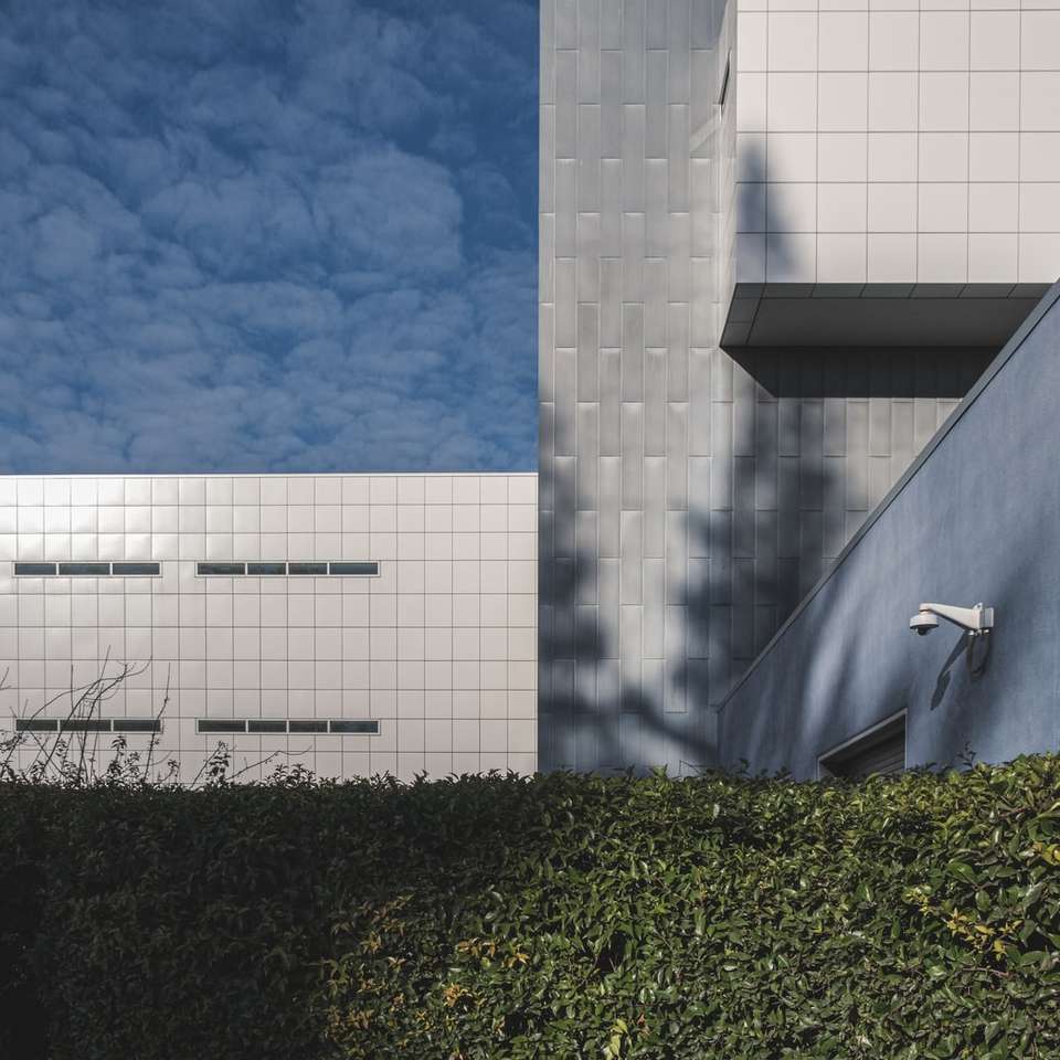 vit betongbyggnad under blå himmel under dagtid Pussel online