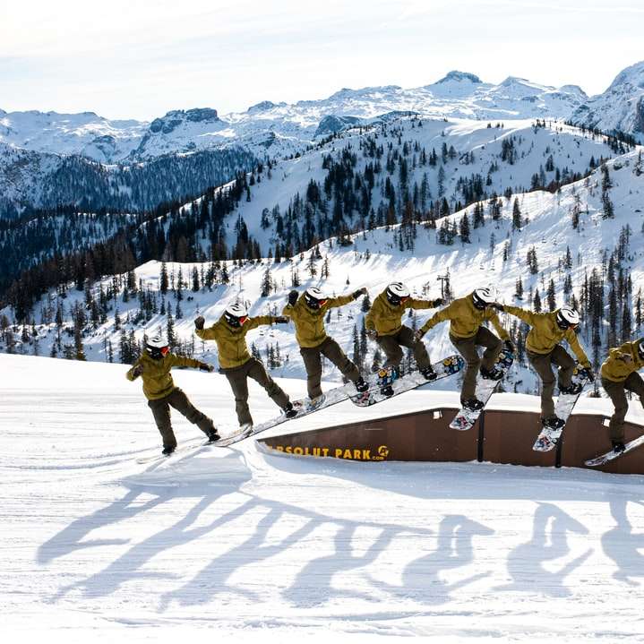 La gente montando telesquí en la montaña cubierta de nieve puzzle deslizante online