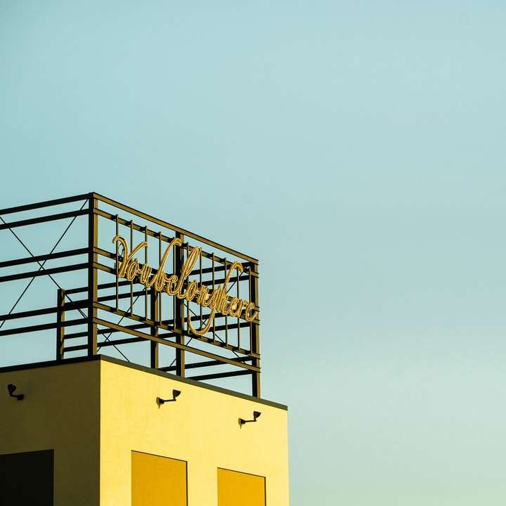 clădire de beton galben sub cer alb în timpul zilei alunecare puzzle online