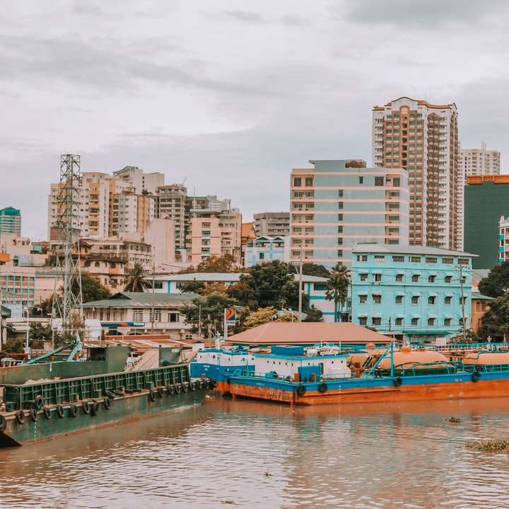 kék és barna csónak a víz közelében a város épületei csúszó puzzle online
