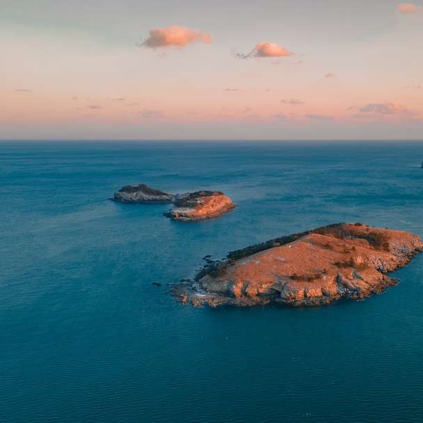 barna sziklaalakzat a kék tengeren, kék ég alatt online puzzle