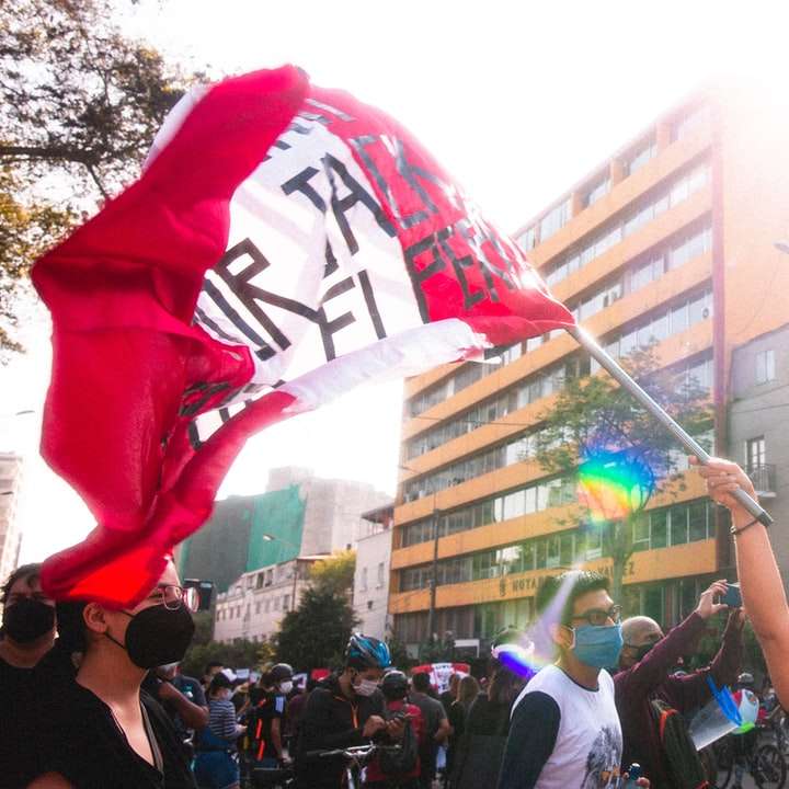 άνθρωποι σε μια πόλη με σημαία μας κατά τη διάρκεια της ημέρας online παζλ