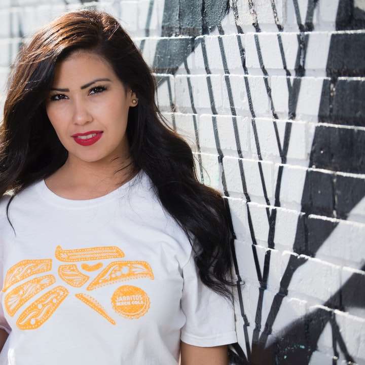 Frau im weißen und orange T-Shirt mit Rundhalsausschnitt, die Flasche hält Schiebepuzzle online