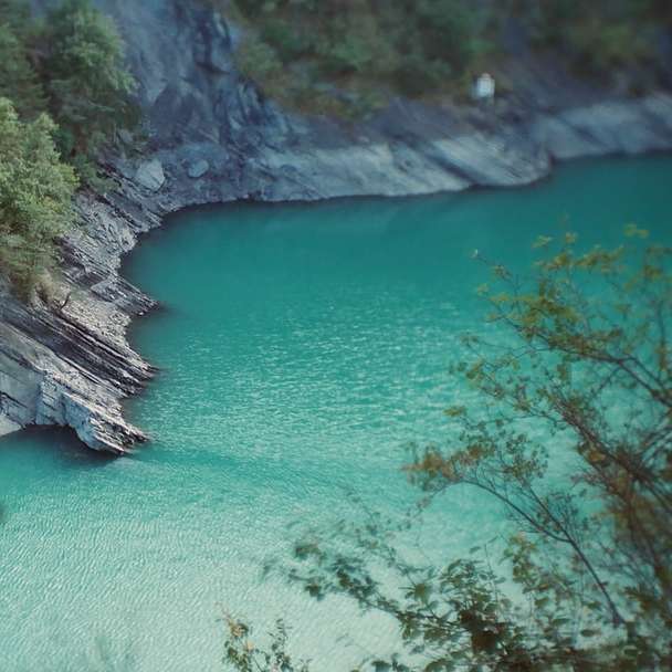 Montaña verde y marrón junto al mar azul durante el día rompecabezas en línea